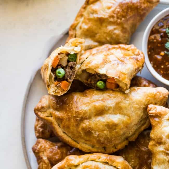 Air fryer empanadas filled with ground beef, potatoes, peas, and carrots.