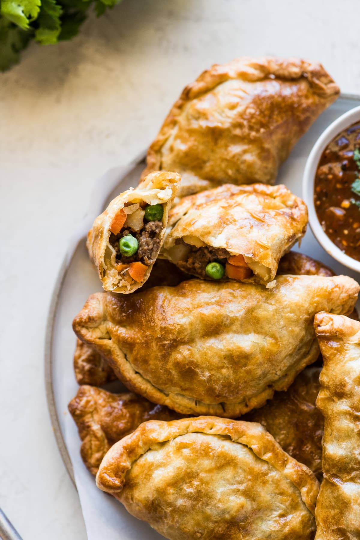 Air fryer empanadas filled with ground beef, potatoes, peas, and carrots.