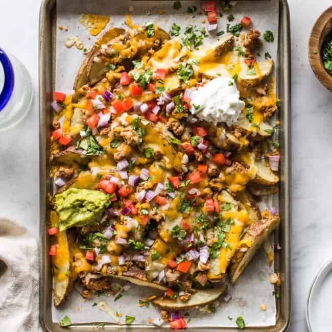 Loaded baked potato wedges made from potato wedges covered in melted cheese.