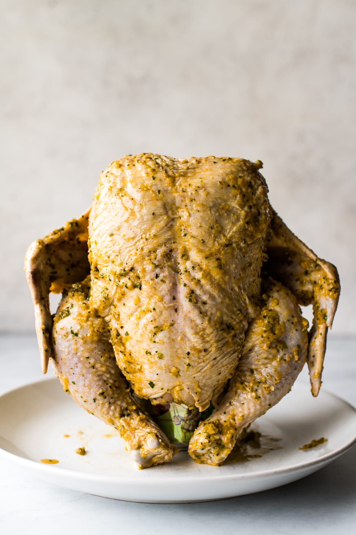 A marinated beer can chicken ready to be grilled.
