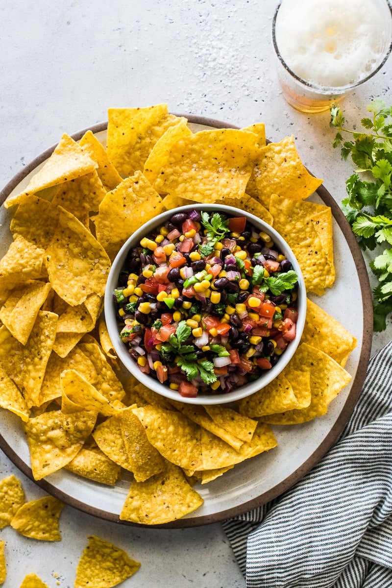 Black bean and corn salsa in a bowl surrounded by tortilla chips.