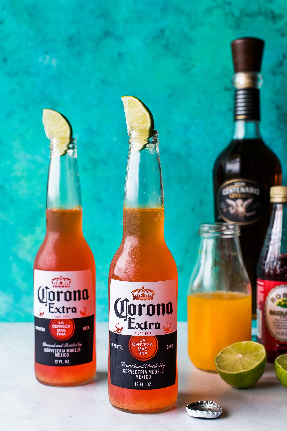Corona sunrise drink with lime wedge in bottle.