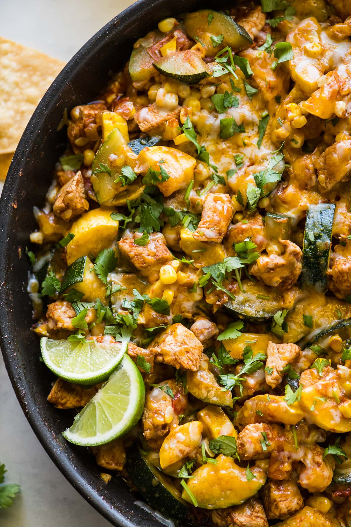 A southwest chicken and squash skillet topped with cheese and cilantro.
