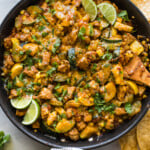 Chicken and Squash in a skillet with cilantro and limes.