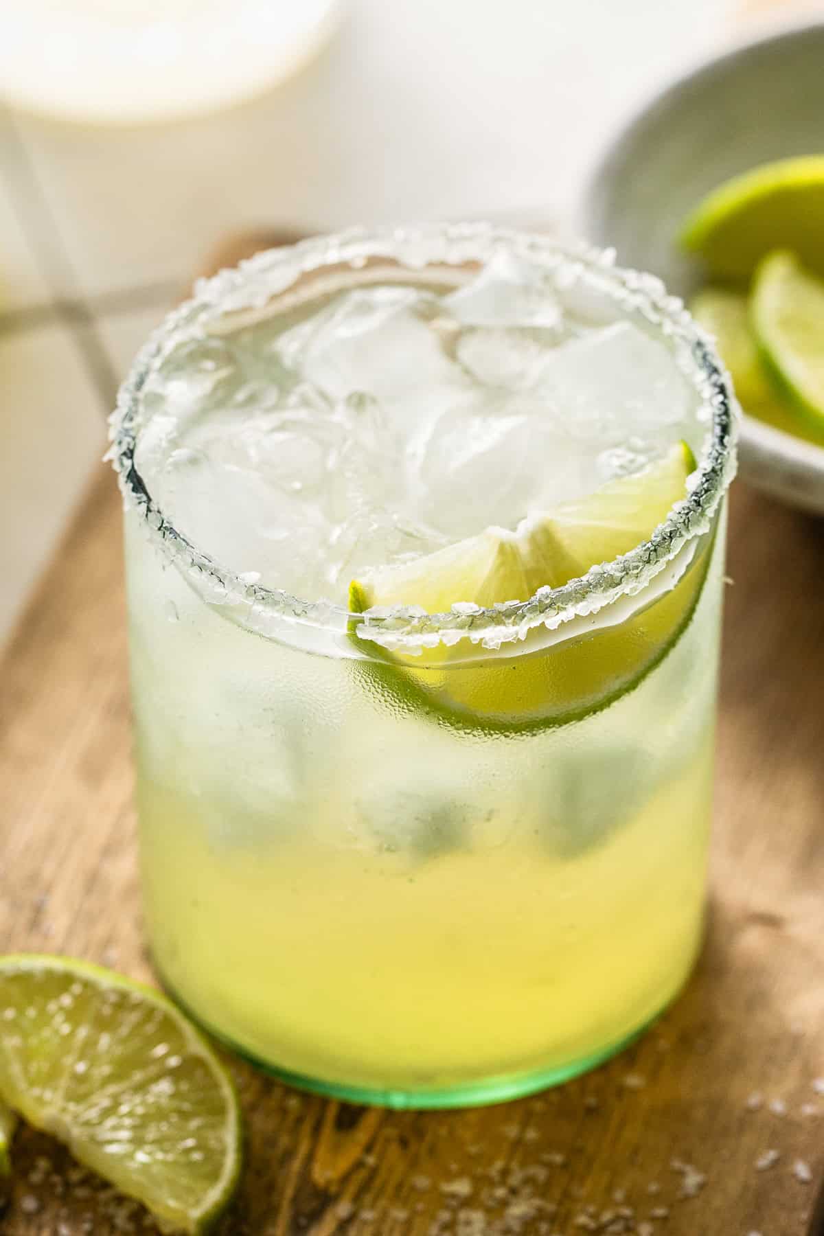 A classic margarita recipe served on the rocks with a coarse salt rim and fresh lime.