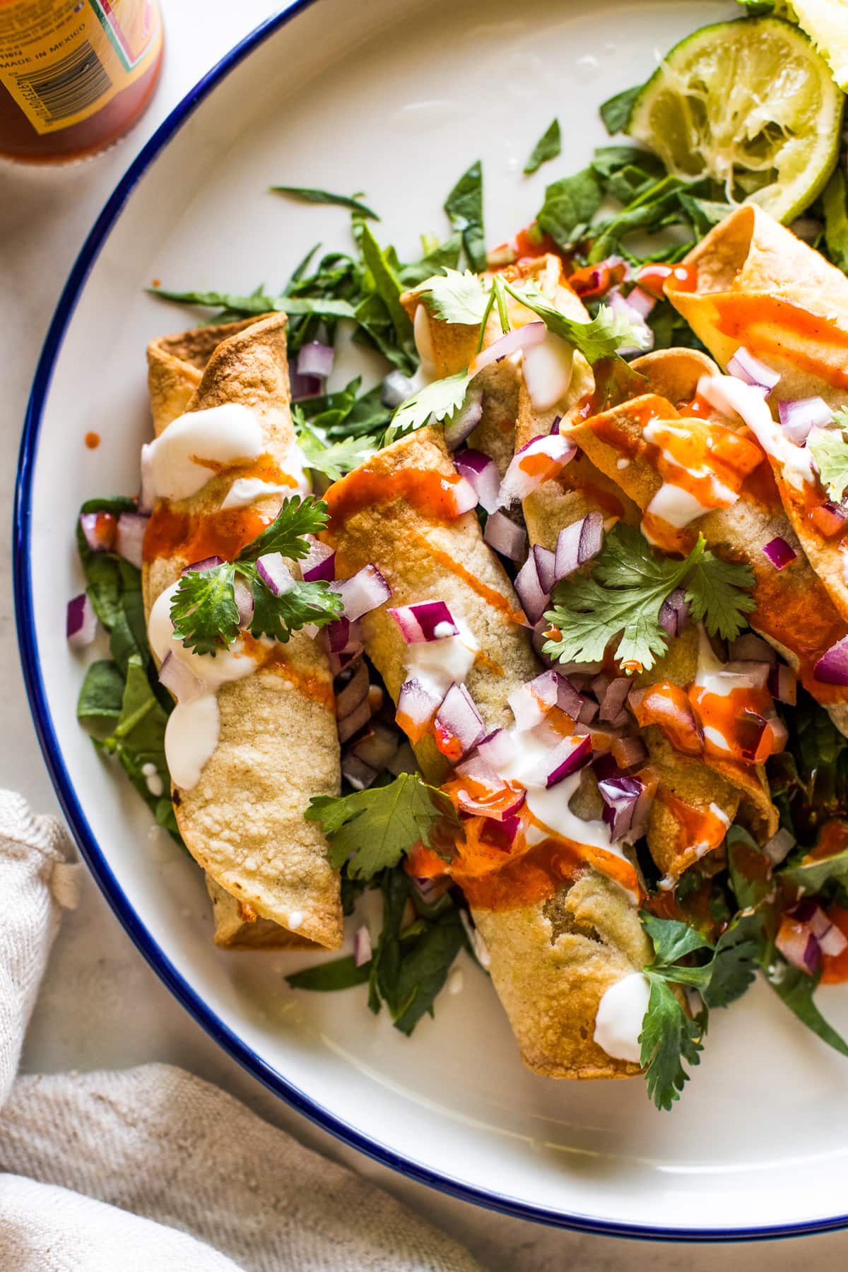 Crispy air fryer taquitos topped with Mexican toppings and ready to eat.