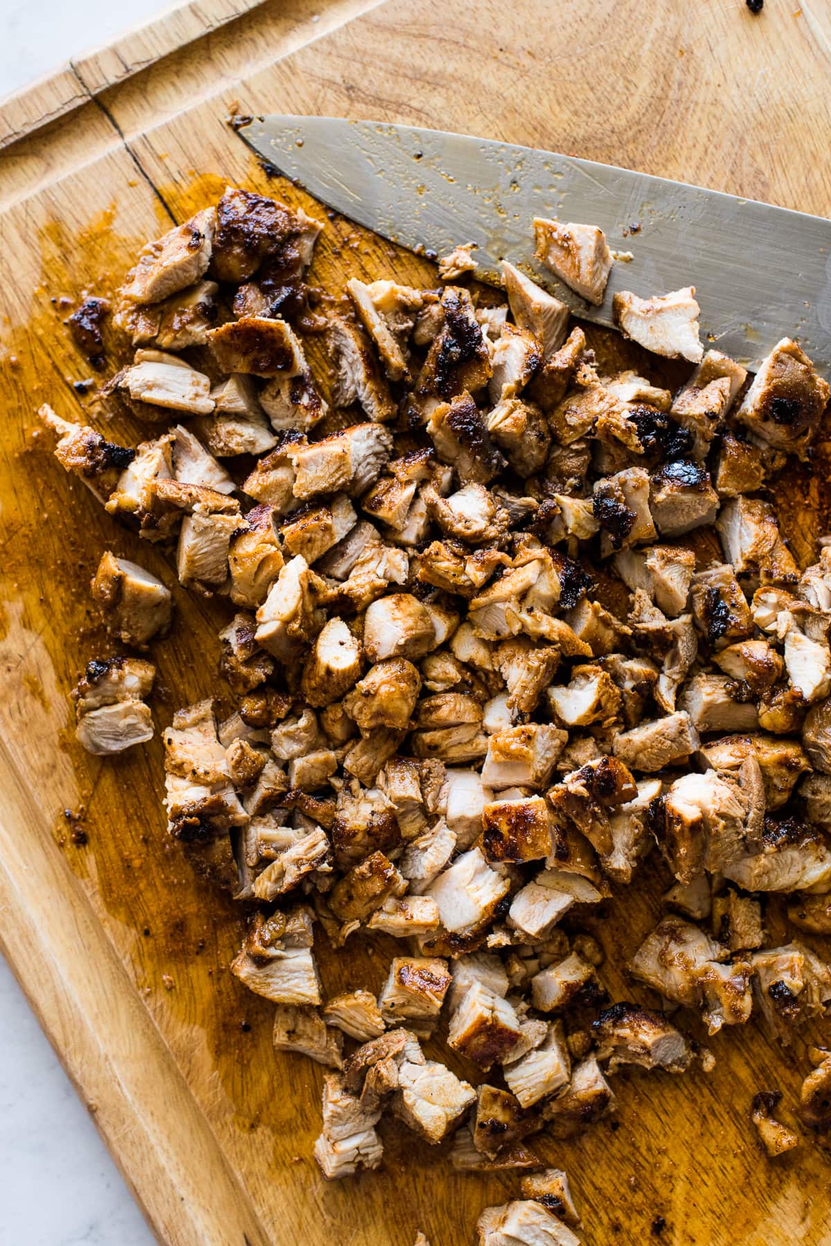 Juicy and tender diced chicken on a cutting board.