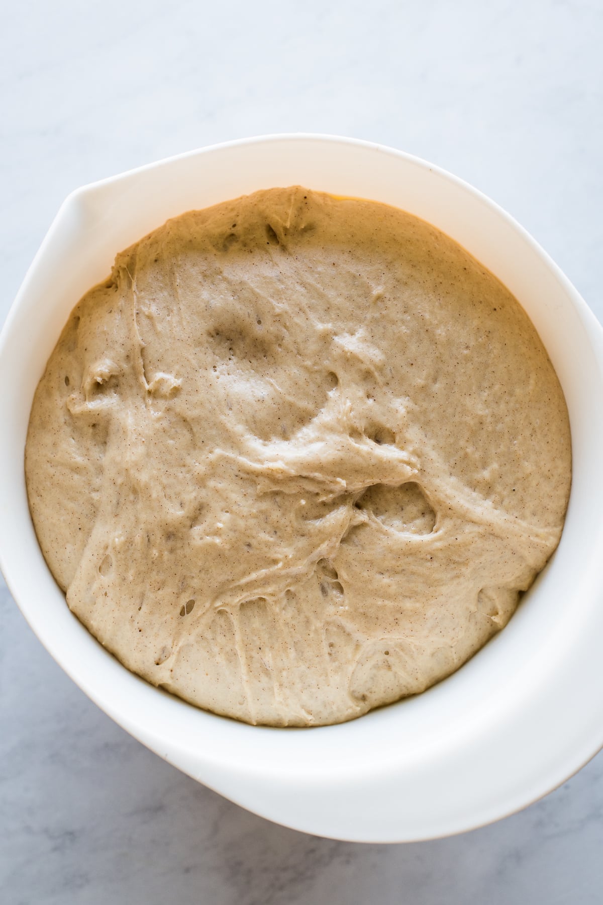 Yeasted bread dough for pumpkin empanadas in a bowl.