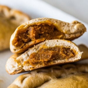 Pumpkin Empanadas cut in half with pumpkin filling exposed.