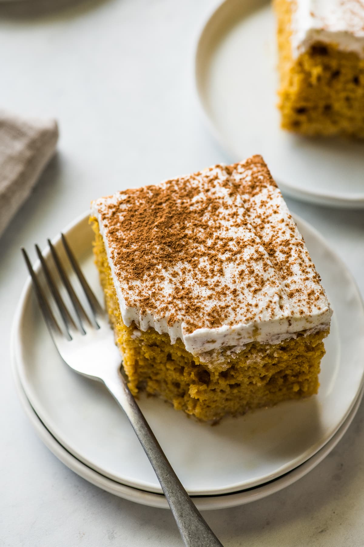A slice of pumpkin tres leches cake with a bite taken out.