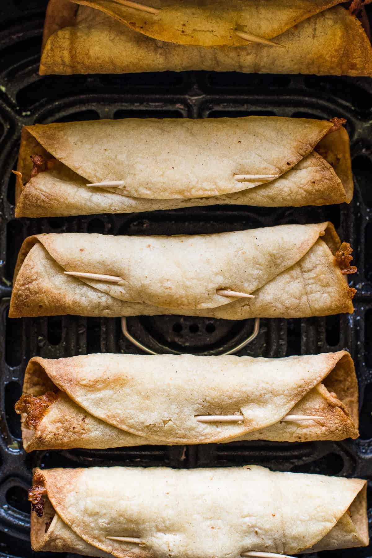 Crispy air fryer taquitos in an air fryer.