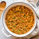 Cooked Mexican rice in a pot with peas mixed in.