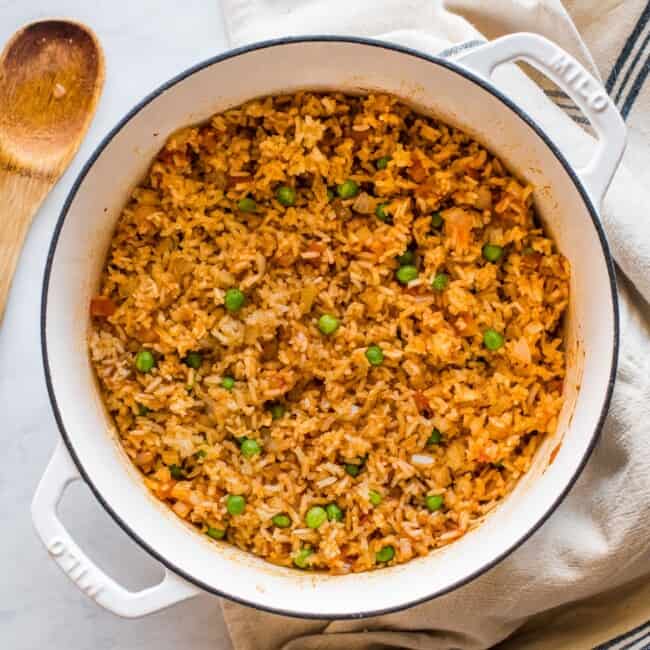 Cooked Mexican rice in a pot with peas mixed in.