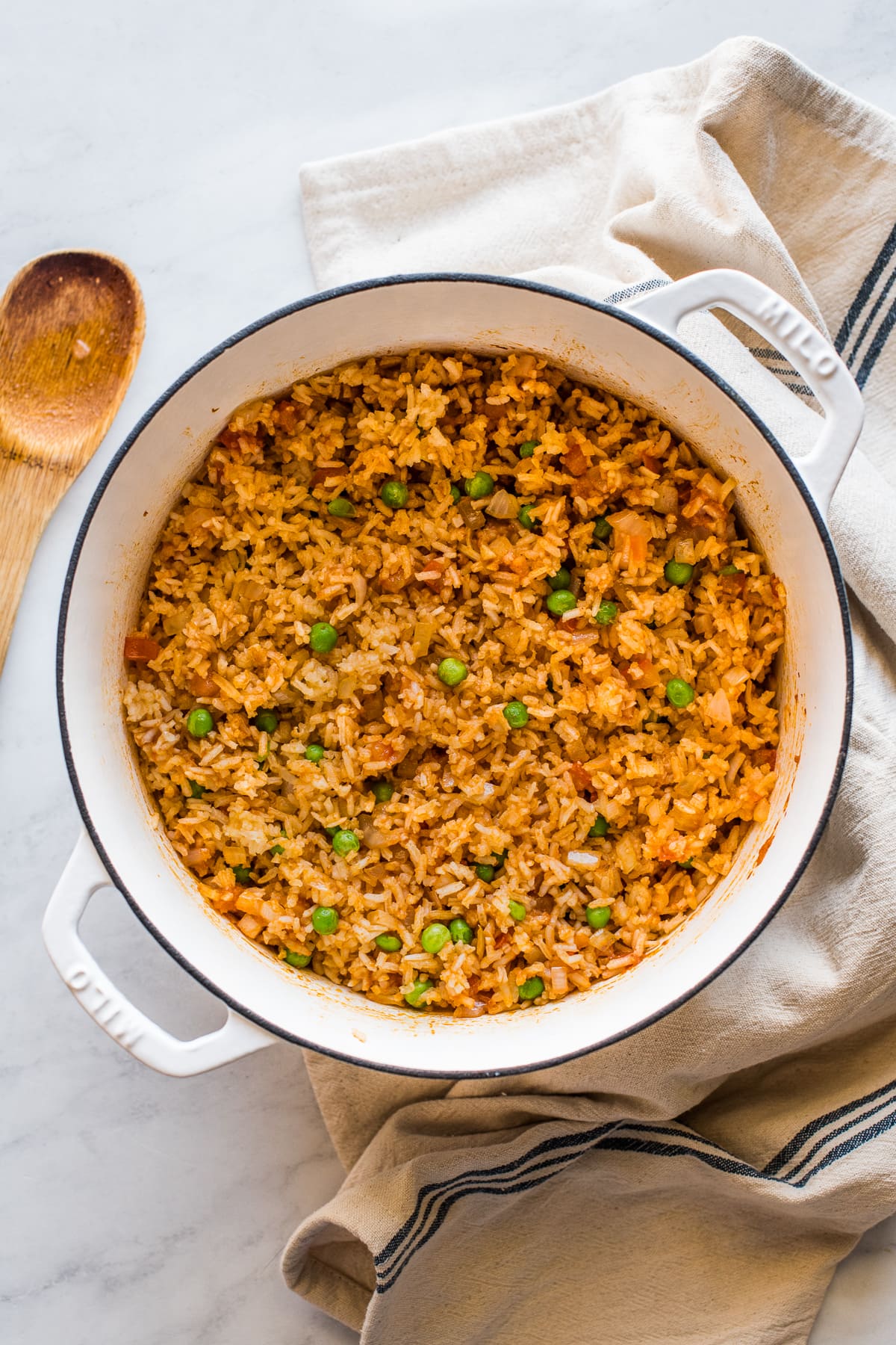 Cooked Mexican rice in a pot with peas mixed in.