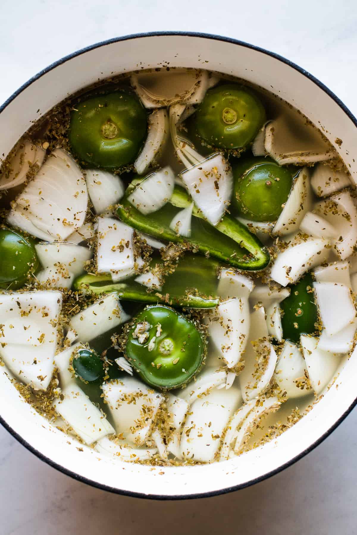 Tomatillos, onions, jalapenos, garlic, and Mexican oregano in a Dutch oven for pozole.
