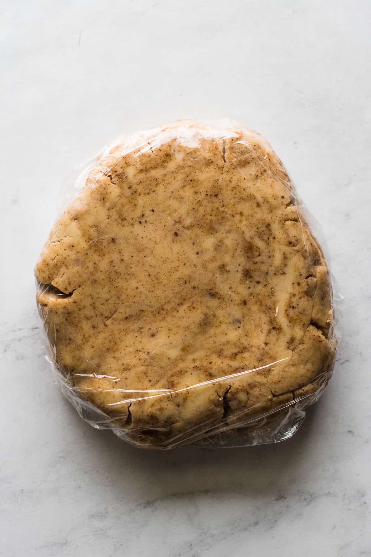 Chilled Mexican Wedding Cookie dough wrapped in plastic wrap.