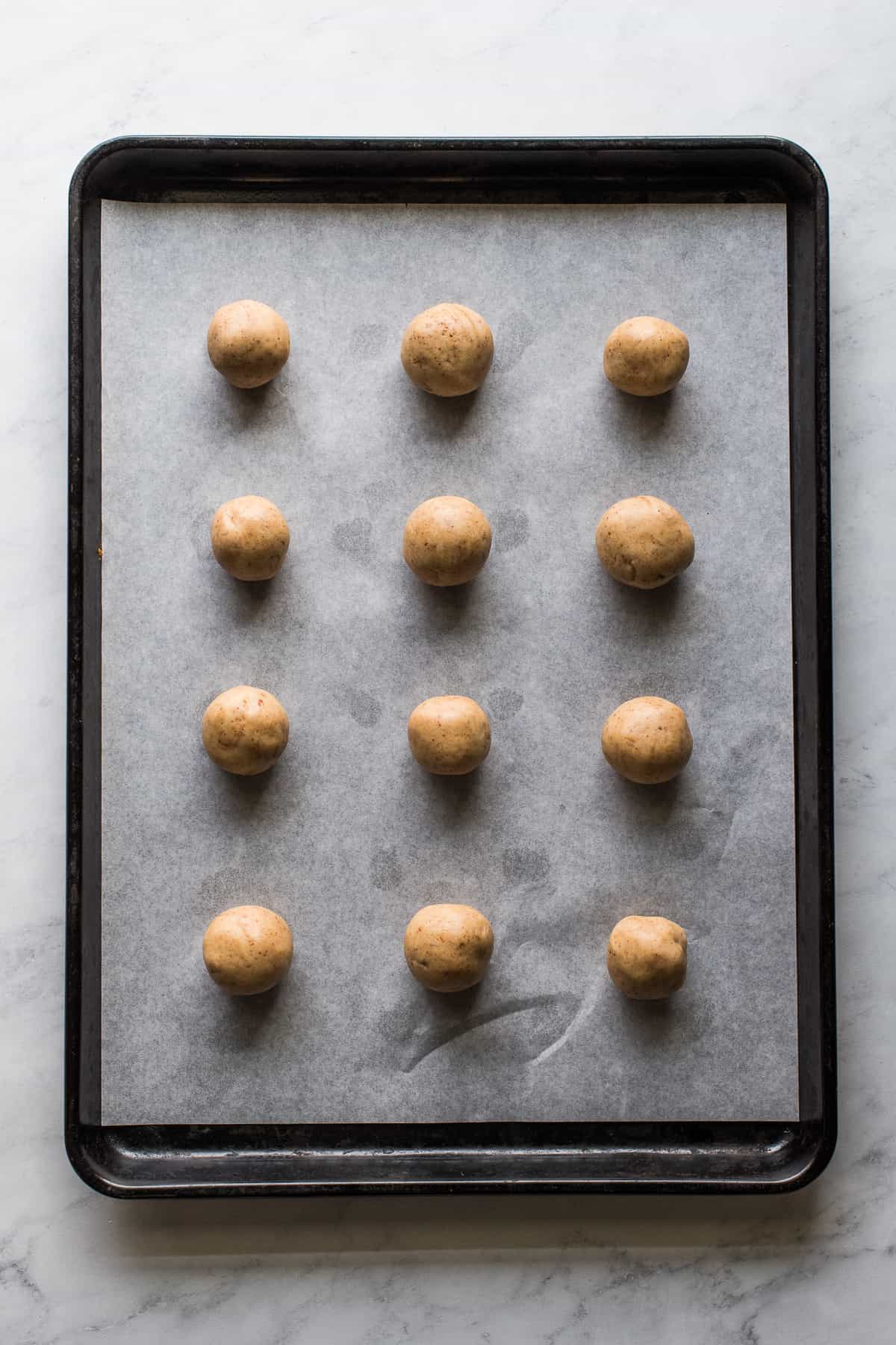 Unbaked Mexican Wedding Cookies on a baking sheet.