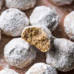 Mexican Wedding Cookies on a plate with one cookie with a bite taken out.