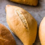 Baked bolillo with a golden brown crust on a baking sheet ready to eat.