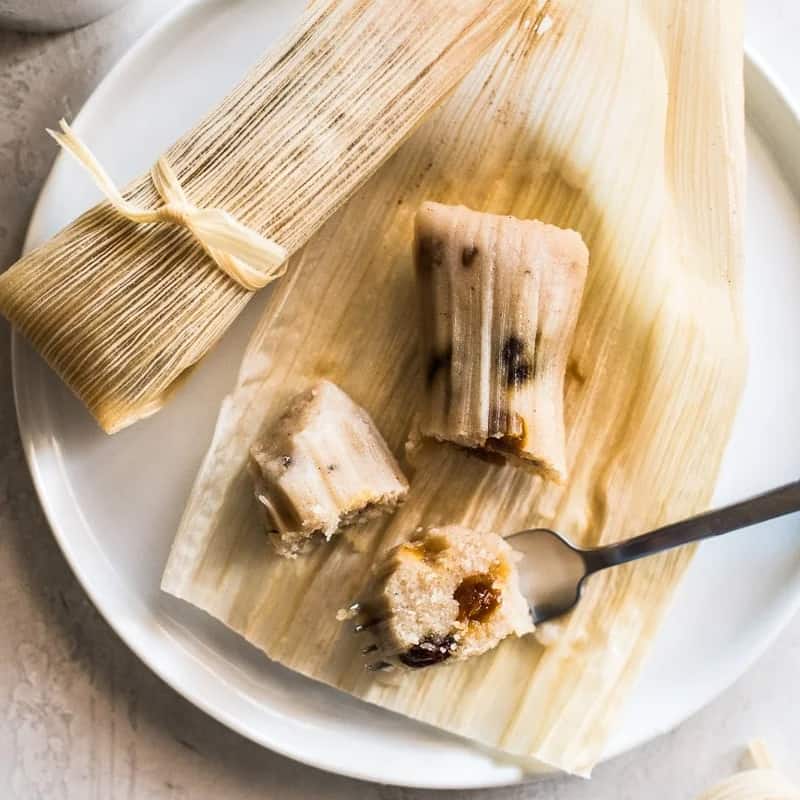Sweet tamales made with regular and golden raisins on a plate.