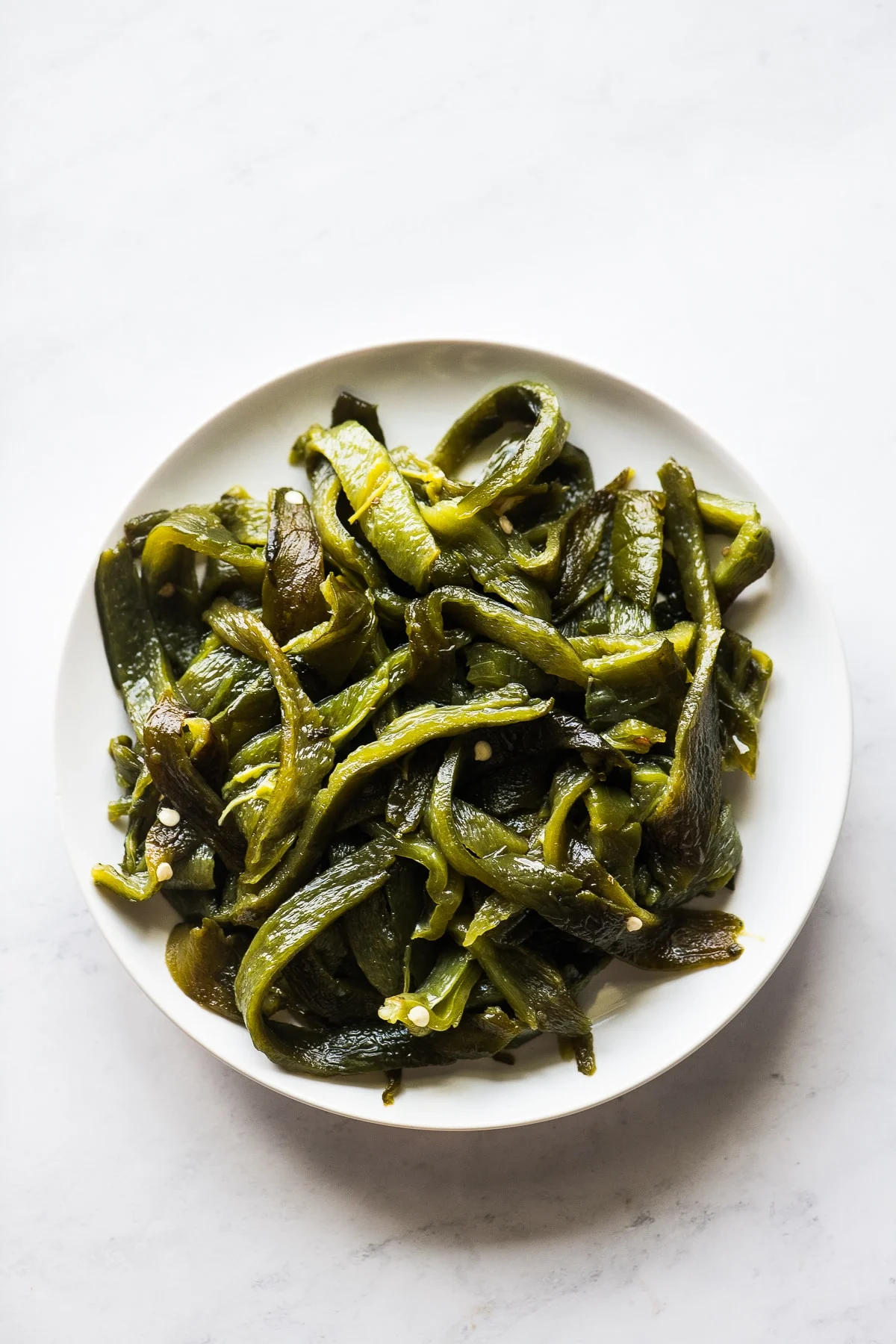 Slices of roasted poblano peppers (also knowns as rajas in spanish) on a plate.