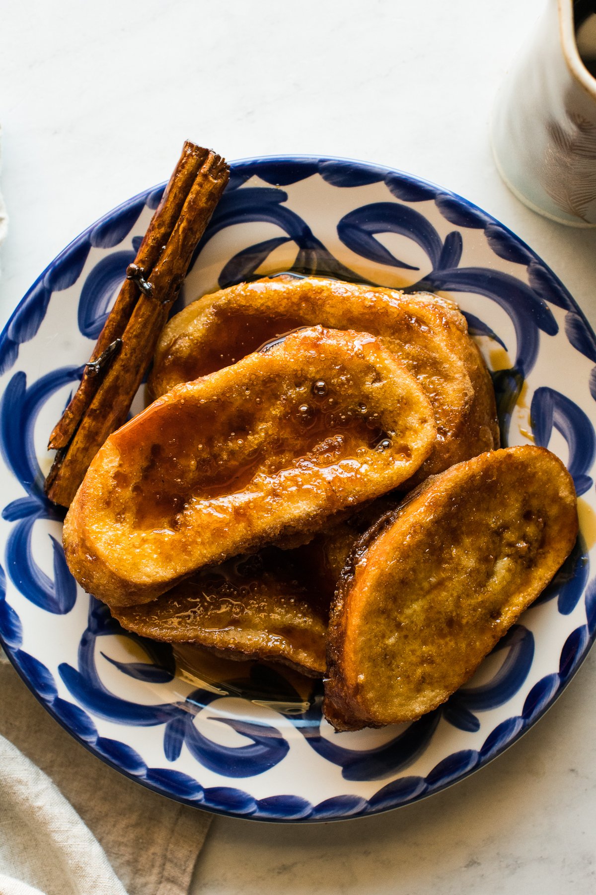 Torrejas drizzled with piloncillo syrup on a plate.