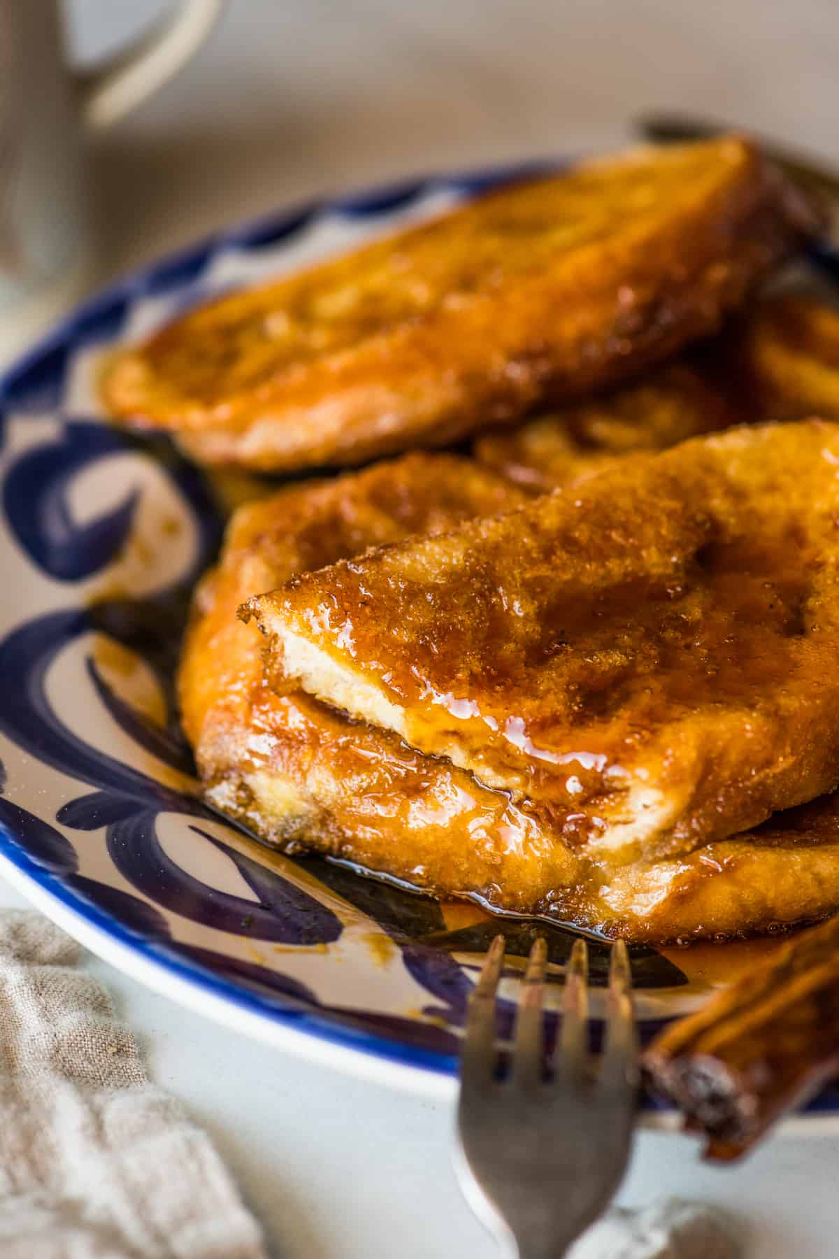 A torreja with a slice cut out so you can see the inside of the fluffy bread.