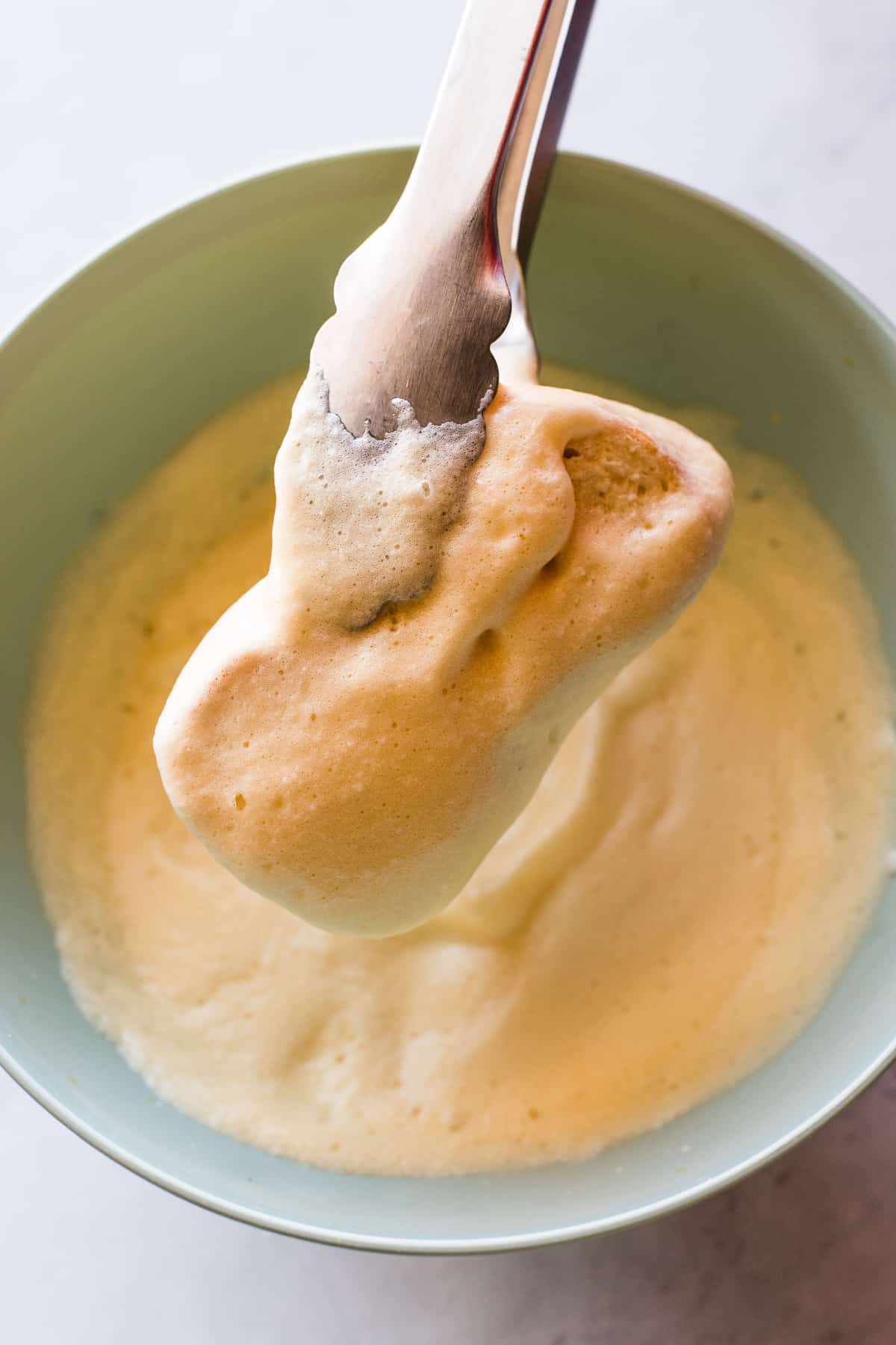 Bolillo bread dipped in a whipped egg mixture for torrejas.