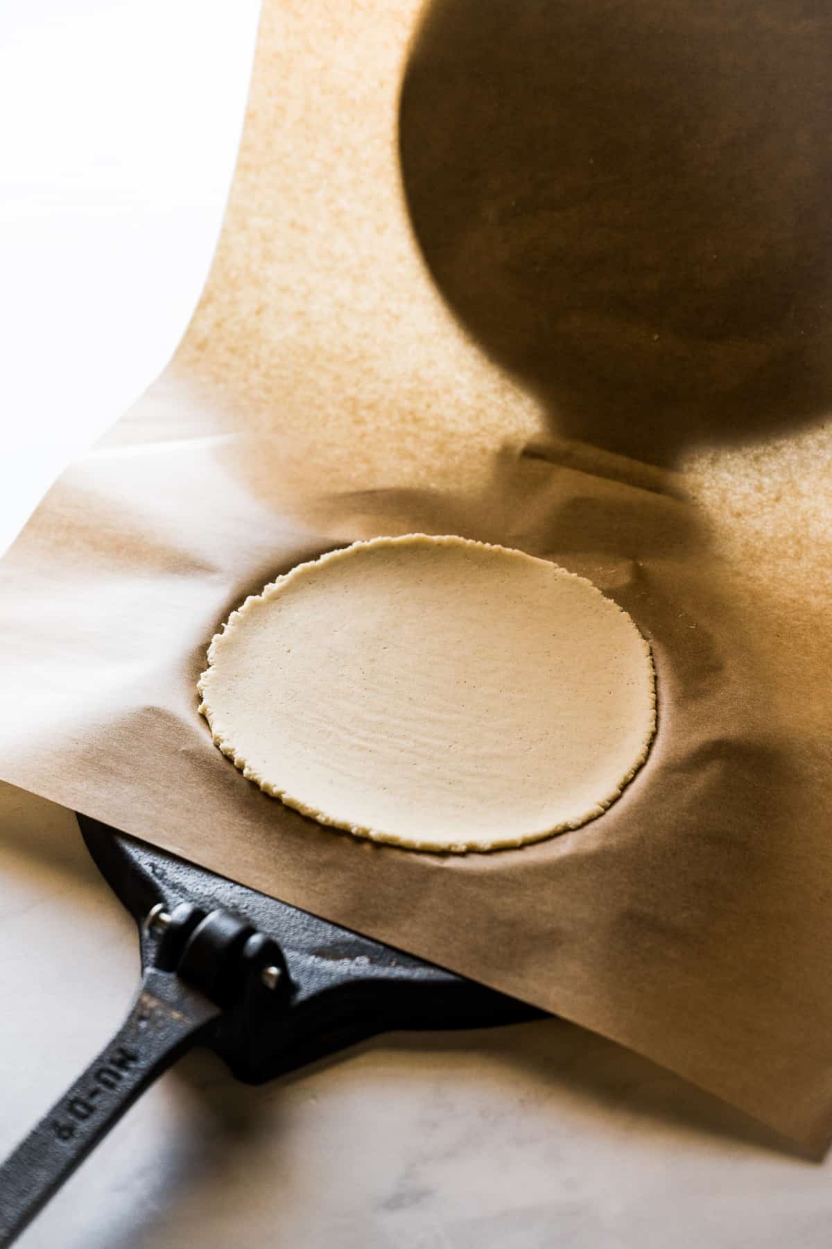 Flattened masa on a tortilla press to make corn tortillas.