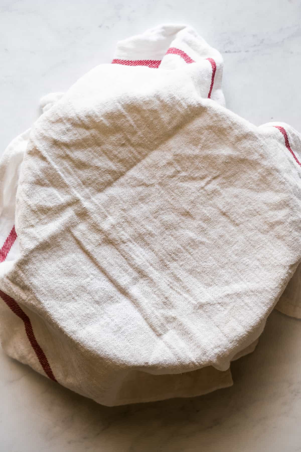 Masa harina being covered with a kitchen towel to keep the dough from drying out.