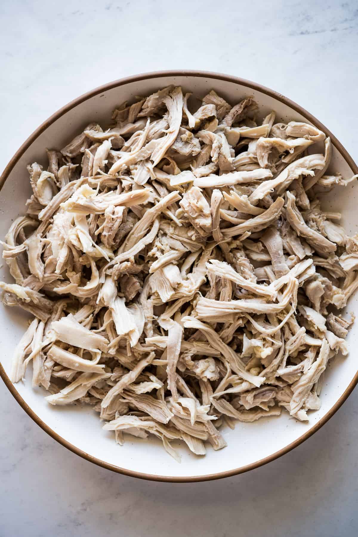 Shredded chicken in a plate for chicken flautas.