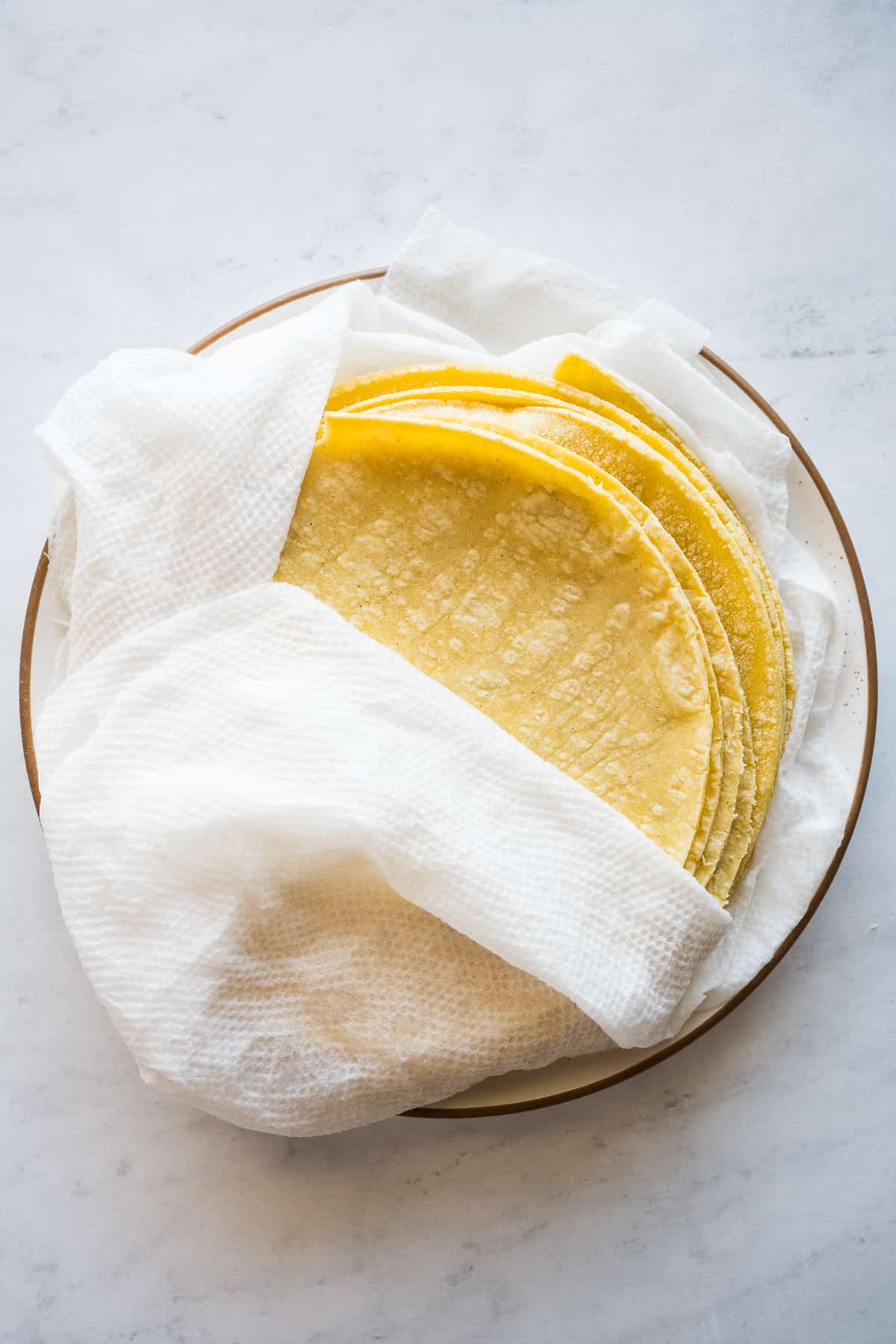 Corn tortillas wrapped in a damp paper towel to keep them moist when being warmed in the microwave.