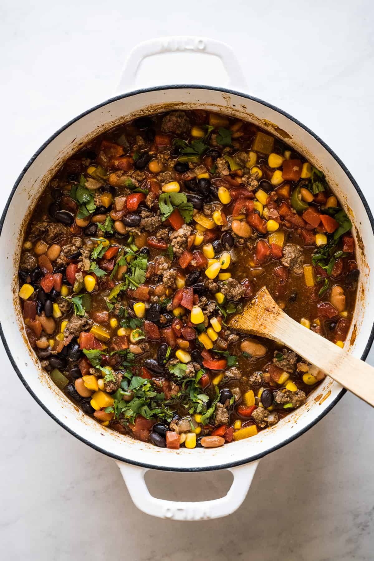 Taco soup in a large pot topped with cilantro and lime juice.