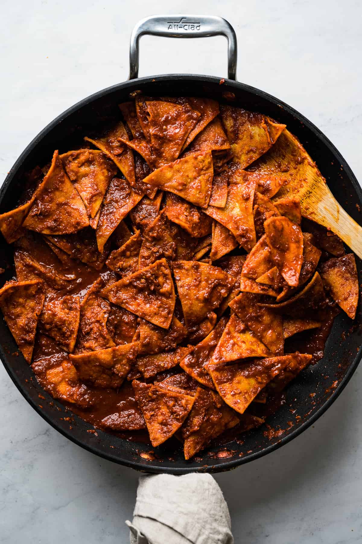 Fried tortilla chips tossed in a red sauce to make chilaquiles.