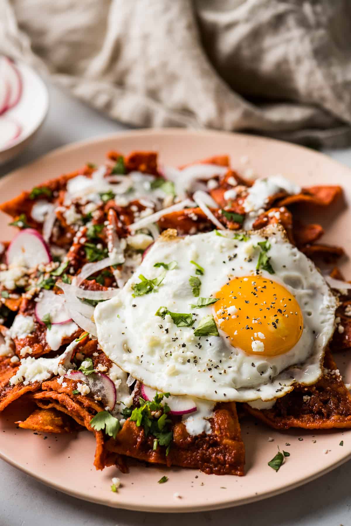 A plate of chilaquiles topped with a fried eggs.