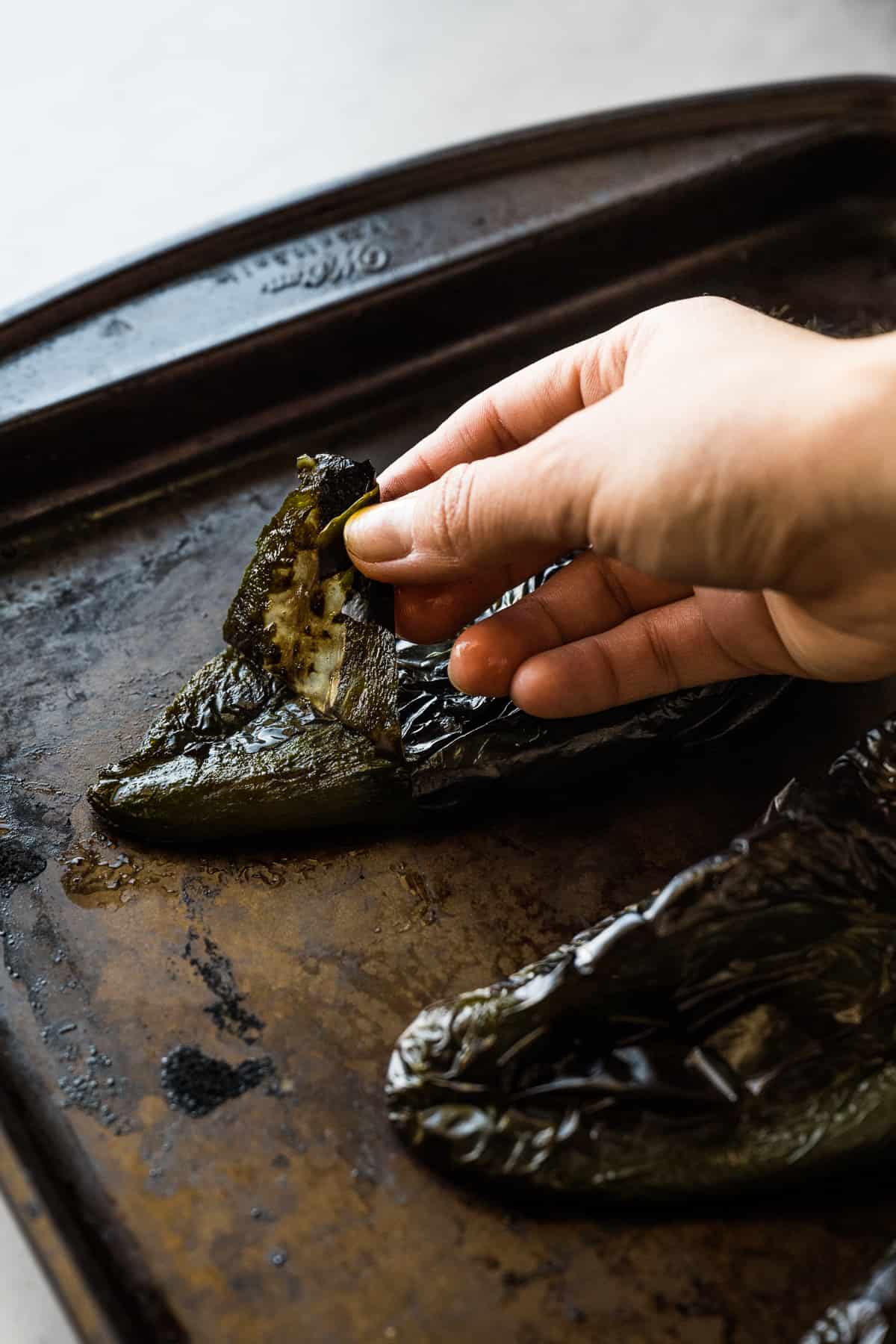 Peeling skin off a roasted poblano pepper.