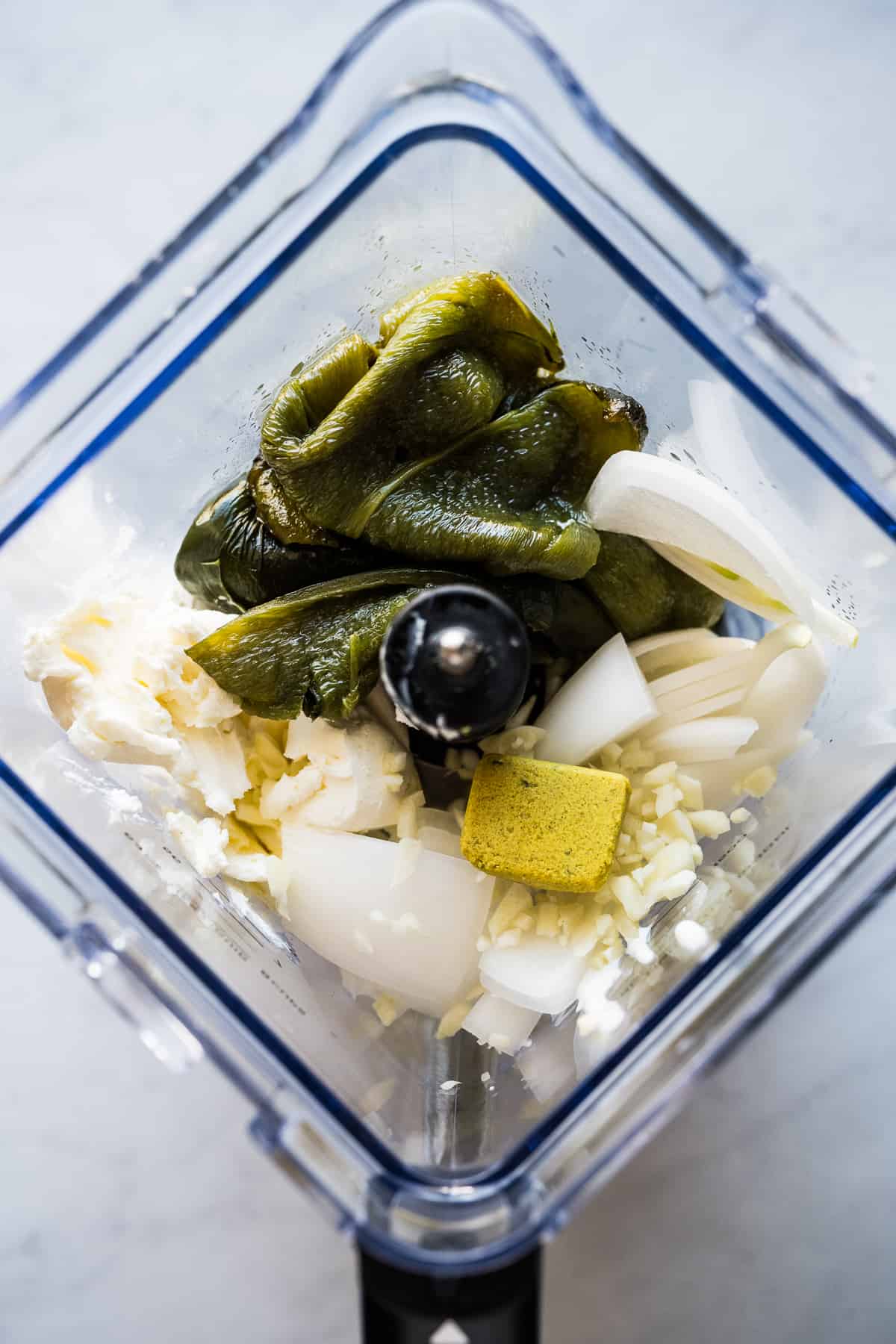 Ingredients for a creamy roasted poblano sauce in a blender.