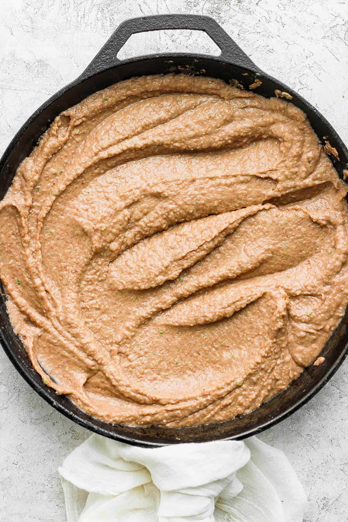 Smooth and creamy refried beans in a skillet ready to be served.