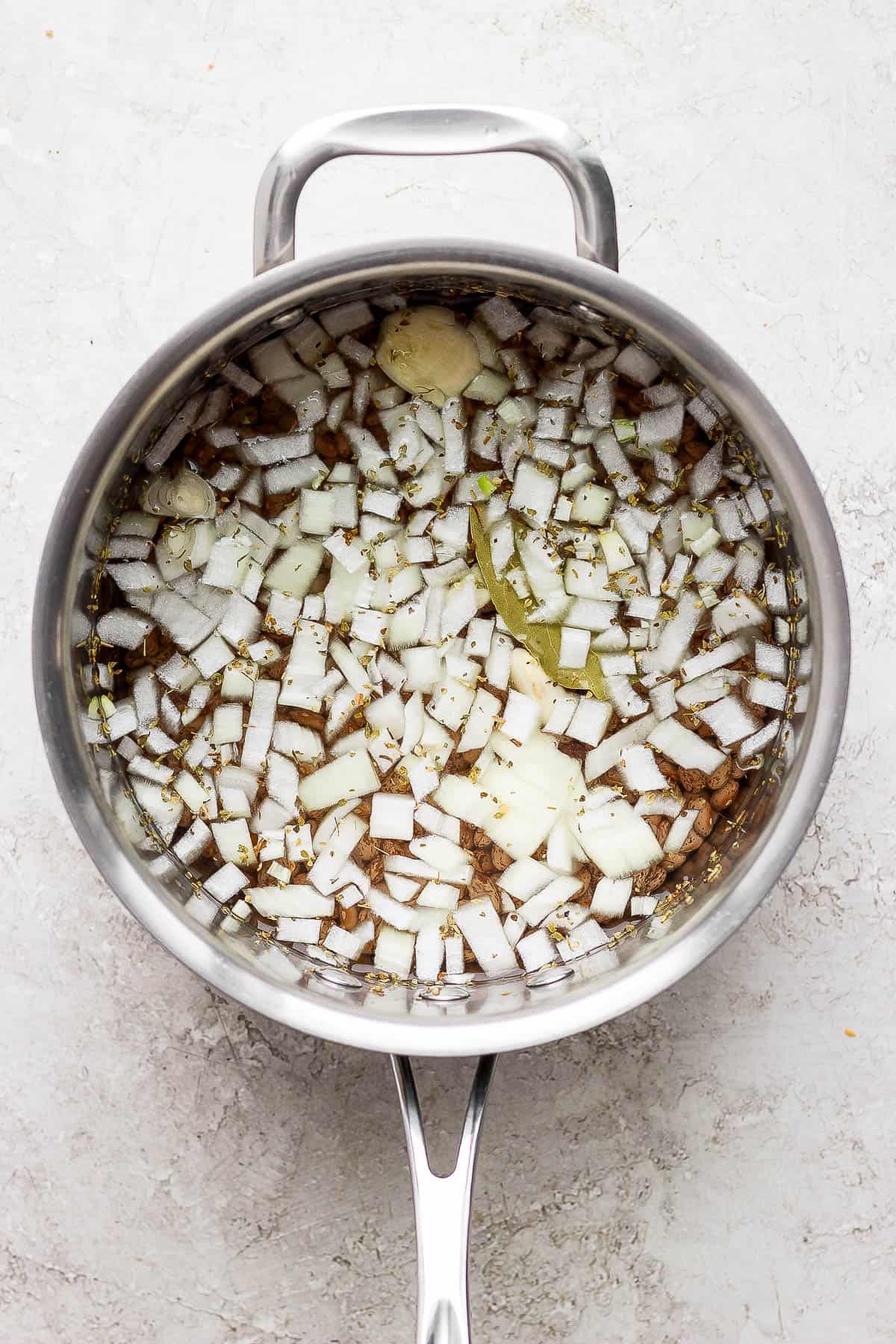 Dry pinto beans in a pot with water getting ready to be cooked and simmered.