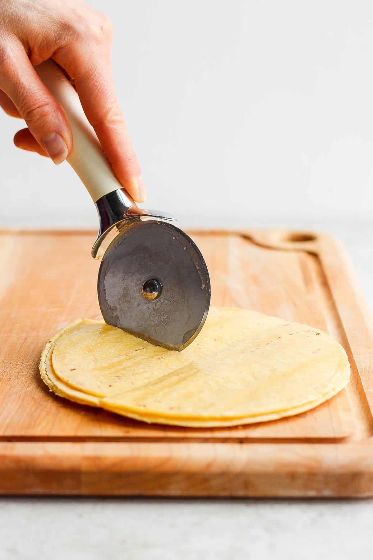 Multiple tortillas stacked and cut into quarters with a pizza cutter