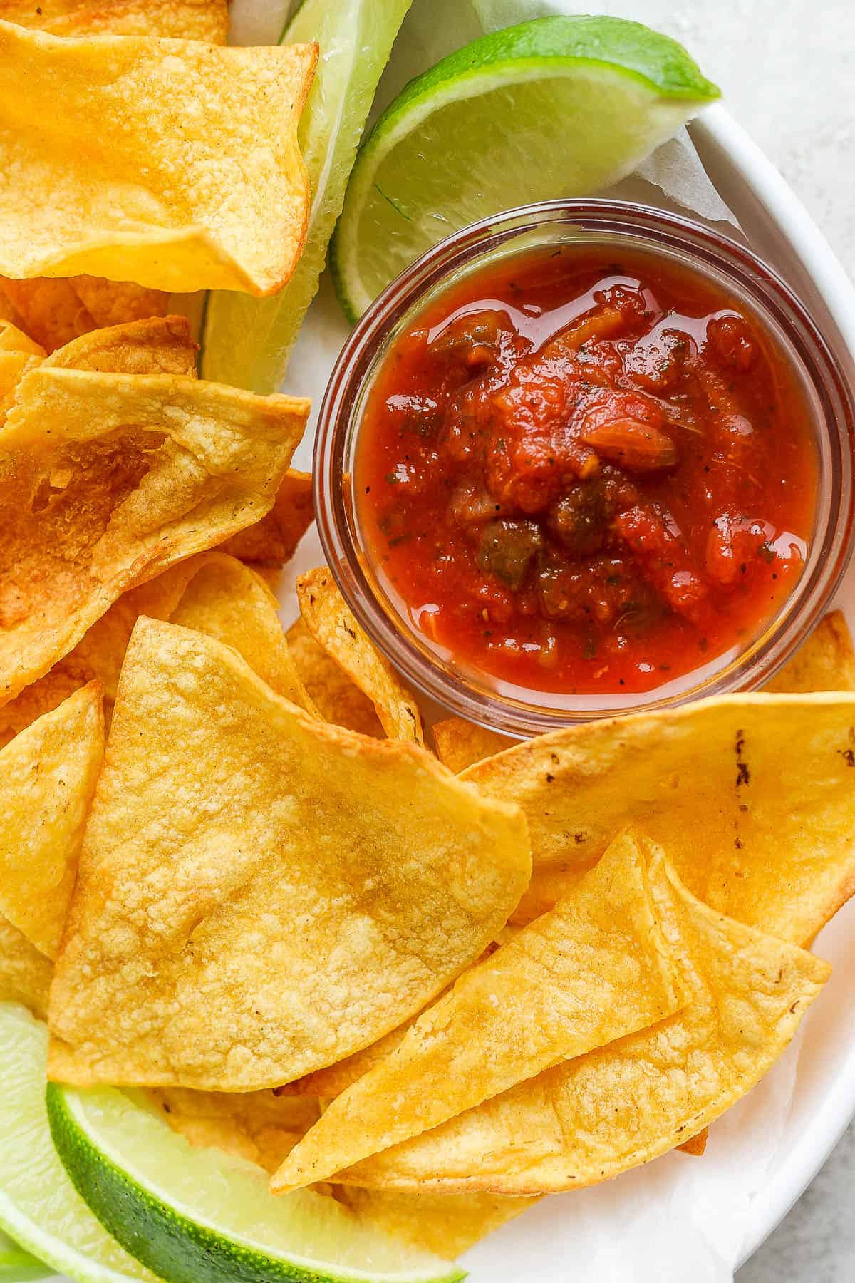 Air fryer tortilla chips with salsa and lime wedges