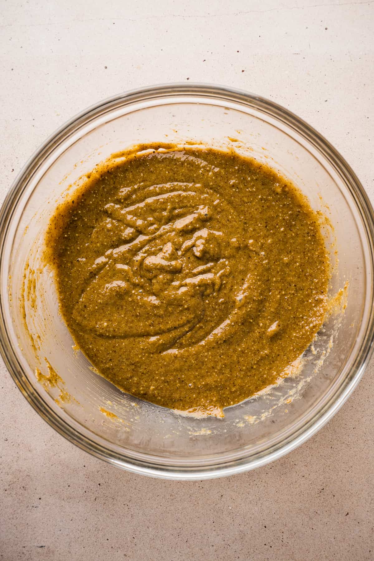 A mixing bowl with a nut butter mixture for chocolate oat bars.