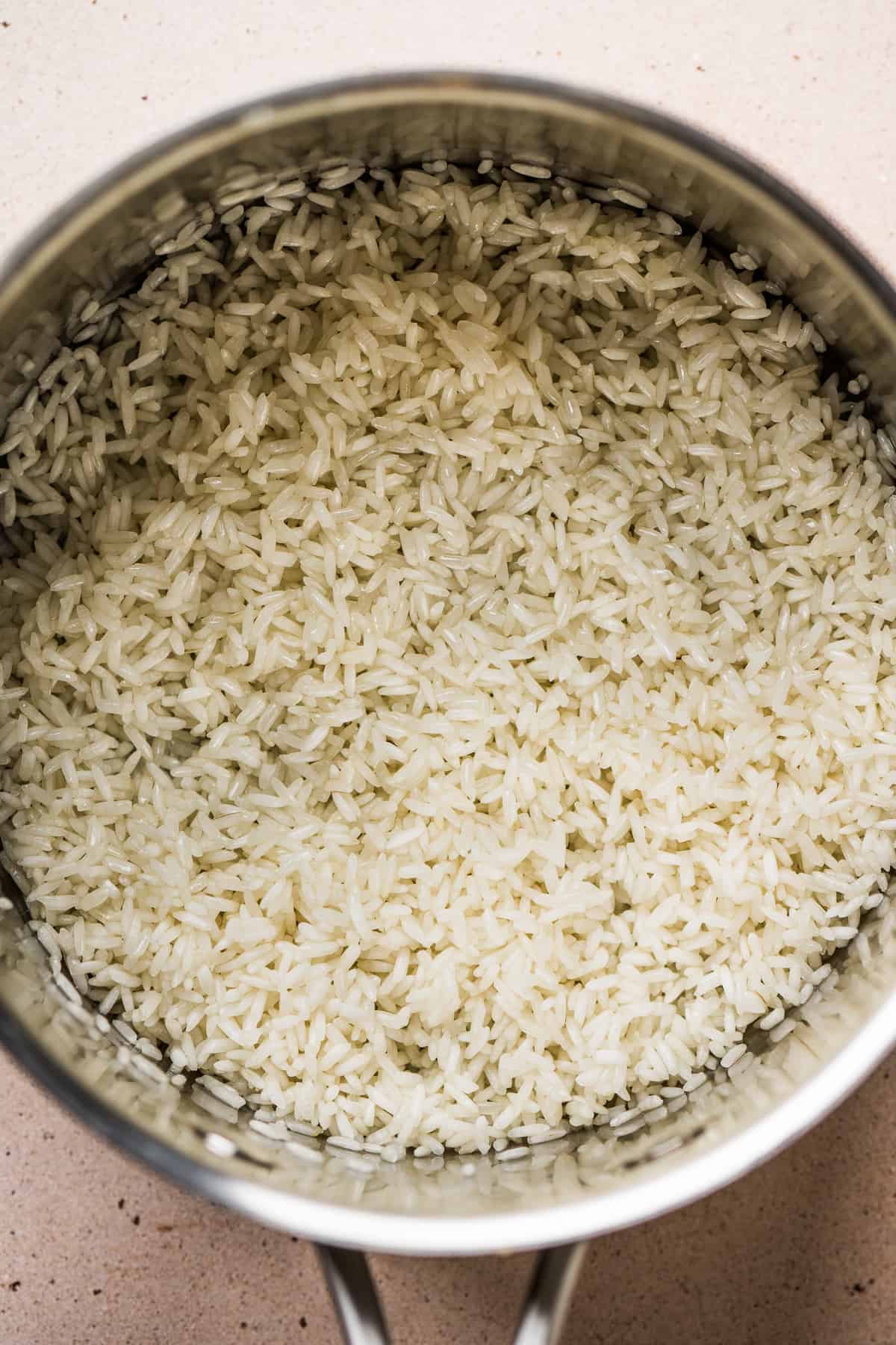 Rinsed rice in a sauce pot toasting in oil 