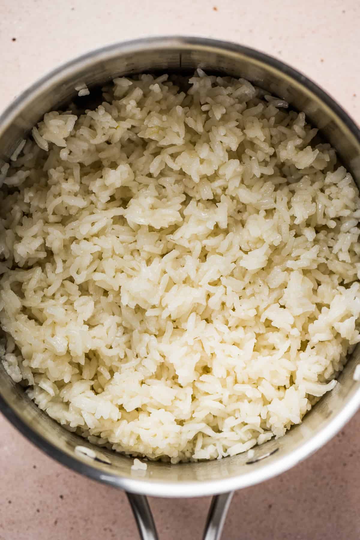 Rice cooking with garlic, salt, and broth in a sauce pot 