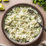 Cilantro lime rice in a serving bowl garnished with chopped cilantro.