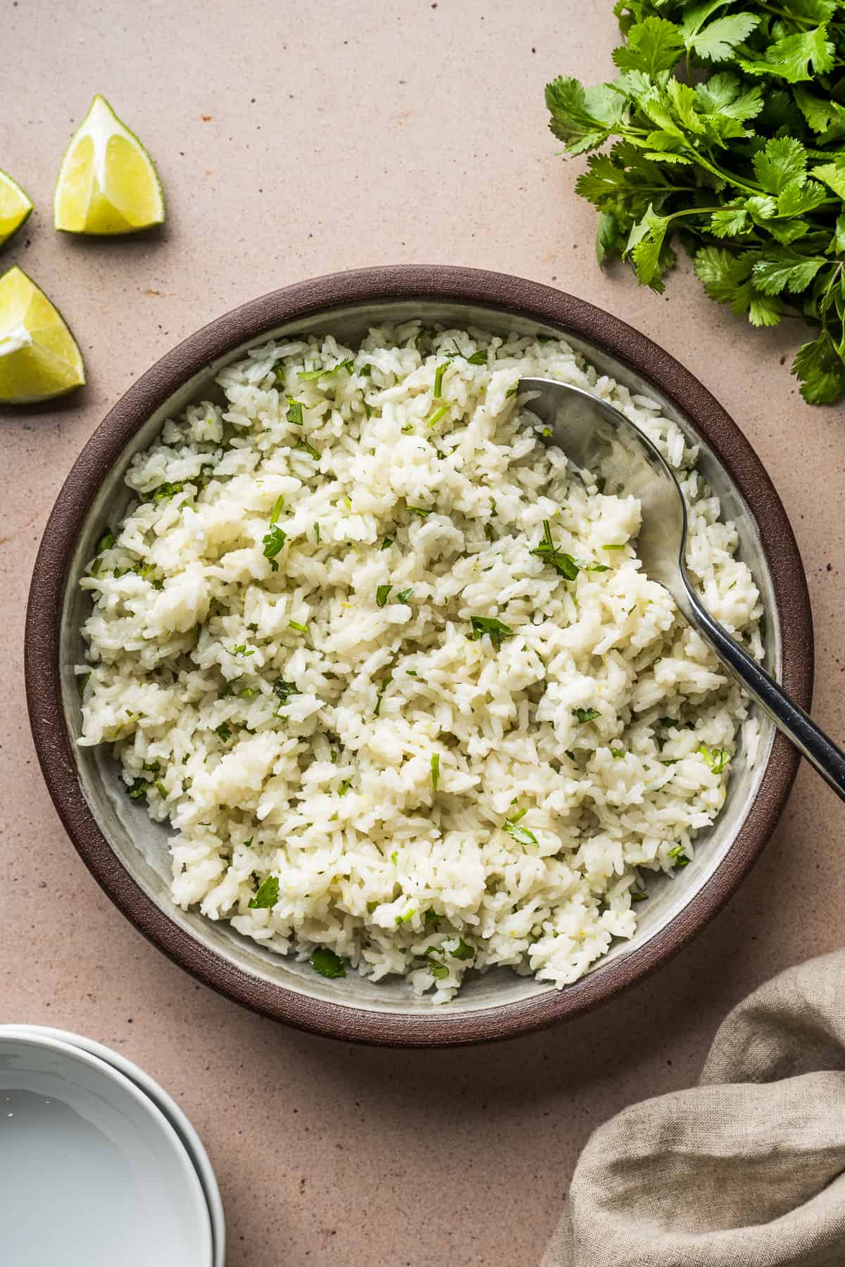 Cilantro lime rice in a serving bowl garnished with chopped cilantro.
