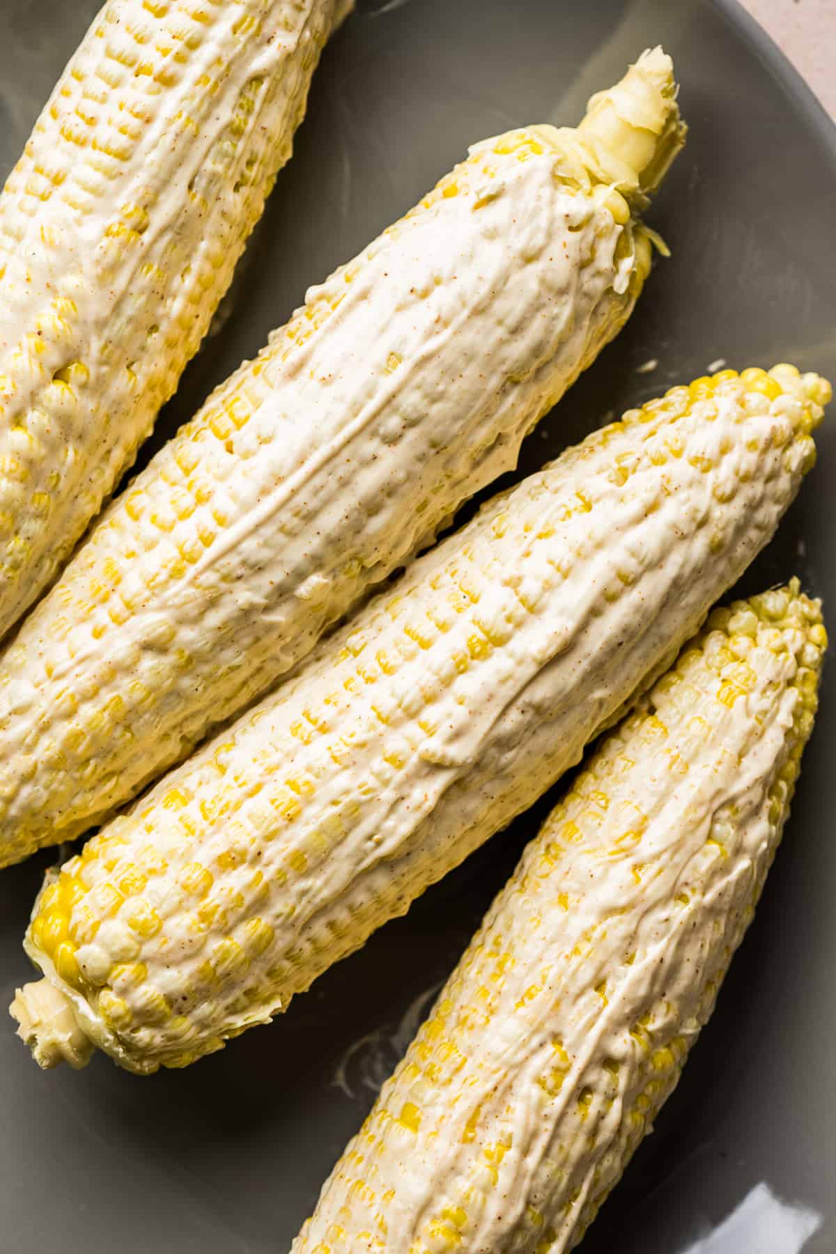 Ears of corn slathered in elote mayo sauce.