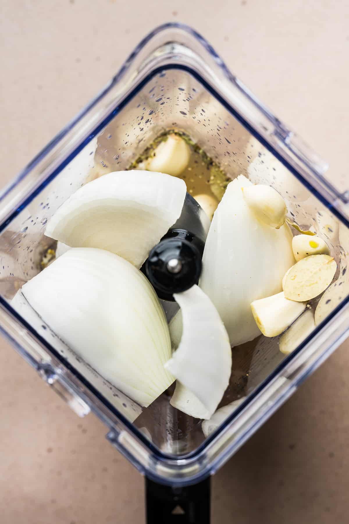 Onions, garlic, oregano, and bay leaves in a blender.