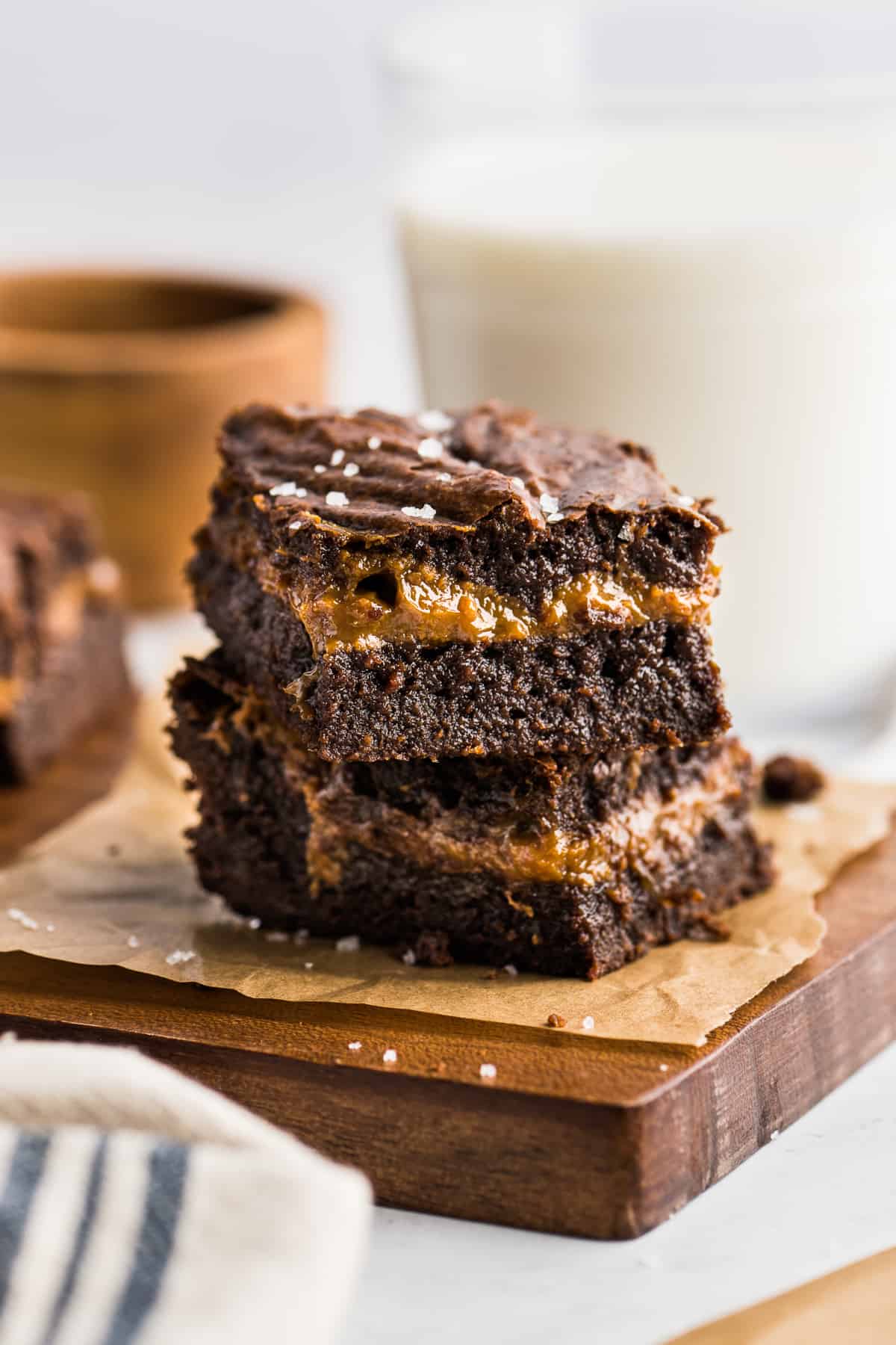 Dulce de leche brownies stacked on top of one another to showcase a layer of dulce de leche in the middle.