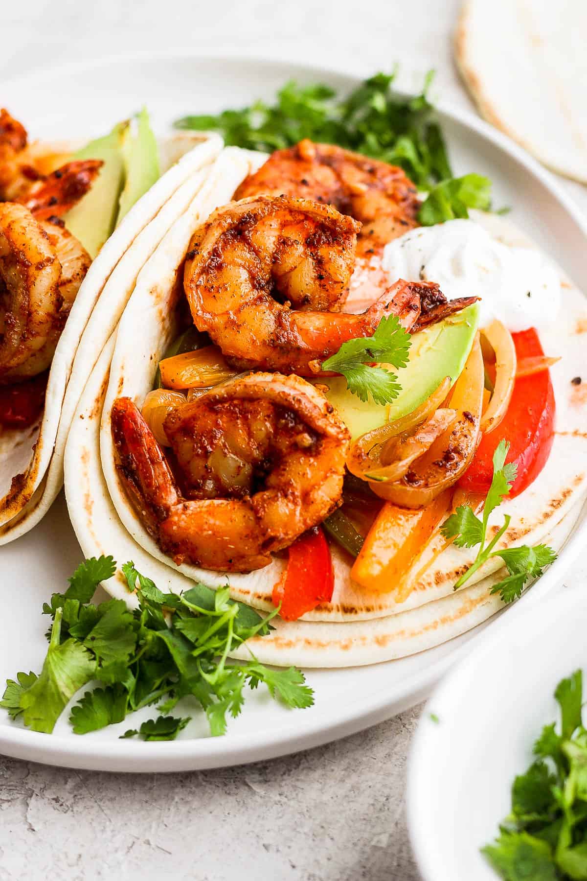 Shrimp Fajitas on warm flour tortillas with avocado and cilantro.